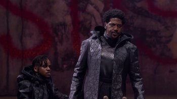 Movie still from “Jesus Christ Superstar Live in Concert” (2018), directed by Alex Rudzinski – A man in a black jacket and a man in a gray jacket; Medium shot, Low angle