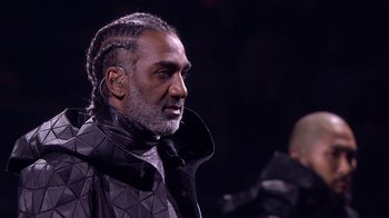Movie still from “Jesus Christ Superstar Live in Concert” (2018), directed by Alex Rudzinski – An older man with a beard and cornrows; Close Up shot, Over the shoulder angle