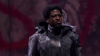 Movie still from “Jesus Christ Superstar Live in Concert” (2018), directed by Alex Rudzinski – A man wearing a black jacket and a silver jacket; Close Up shot, Low angle