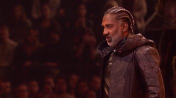 Movie still from “Jesus Christ Superstar Live in Concert” (2018), directed by Alex Rudzinski – A man with a long beard and a jacket on; Close Up shot, High angle