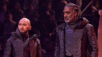Movie still from “Jesus Christ Superstar Live in Concert” (2018), directed by Alex Rudzinski – A couple of men standing next to each other on a stage; Medium shot, Low angle