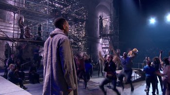 Movie still from “Jesus Christ Superstar Live in Concert” (2018), directed by Alex Rudzinski – A group of people are dancing in a theater; Wide shot, Over the shoulder angle