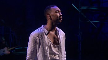 Movie still from “Jesus Christ Superstar Live in Concert” (2018), directed by Alex Rudzinski – A man in a white shirt is looking up; Medium shot, Over the shoulder angle