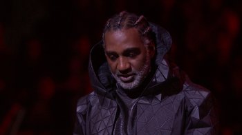 Movie still from “Jesus Christ Superstar Live in Concert” (2018), directed by Alex Rudzinski – A man in a black jacket and a beard; Close Up shot, Low angle