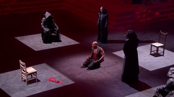 Movie still from “Jesus Christ Superstar Live in Concert” (2018), directed by Alex Rudzinski – A group of men in black and red costumes on a stage; Extreme Wide shot, High angle