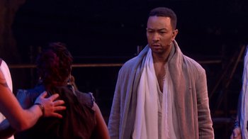 Movie still from “Jesus Christ Superstar Live in Concert” (2018), directed by Alex Rudzinski – A man with a towel around his neck; Medium shot, Over the shoulder angle