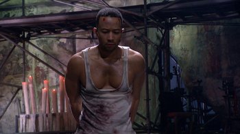 Movie still from “Jesus Christ Superstar Live in Concert” (2018), directed by Alex Rudzinski – A man in a white tank top with blood all over his face; Medium shot, High angle