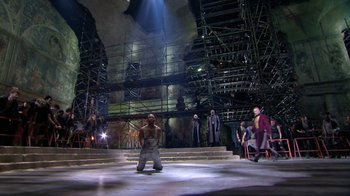 Movie still from “Jesus Christ Superstar Live in Concert” (2018), directed by Alex Rudzinski – A group of people standing on top of a stage; Extreme Wide shot, Low angle