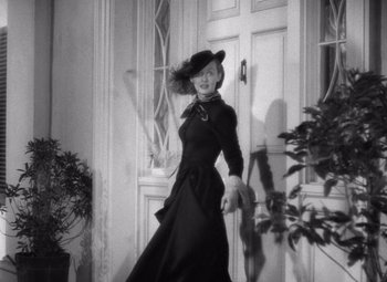 Movie still from “Jezebel” (1938), directed by William Wyler – A woman wearing a hat and a black dress; Medium shot, Low angle