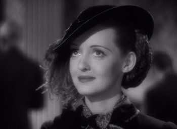 Movie still from “Jezebel” (1938), directed by William Wyler – A black and white photo of a woman wearing a hat; Close Up shot, High angle