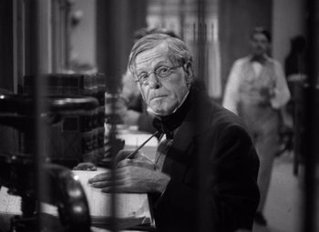 Movie still from “Jezebel” (1938), directed by William Wyler – An older man in a black jacket is looking at the camera; Close Up shot, Over the shoulder angle