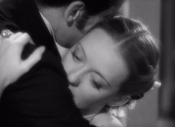 Movie still from “Jezebel” (1938), directed by William Wyler – A black and white photo of a man and a woman kissing; Close Up shot, High angle