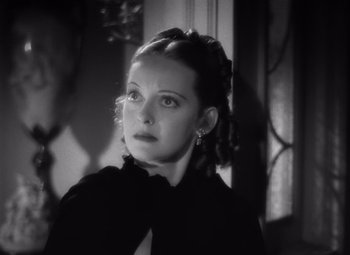 Movie still from “Jezebel” (1938), directed by William Wyler – A black and white photo of a woman looking at the camera; Close Up shot, Low angle