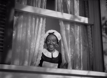 Movie still from “Jezebel” (1938), directed by William Wyler – A black and white photo of a woman looking out of a window; Medium shot, Low angle
