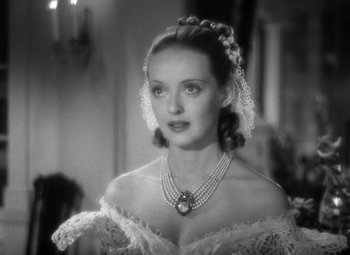 Movie still from “Jezebel” (1938), directed by William Wyler – A black - and - white photo of a woman wearing a necklace; Close Up shot, Over the shoulder angle