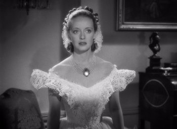 Movie still from “Jezebel” (1938), directed by William Wyler – A black and white photo of a woman in a dress; Close Up shot, Over the shoulder angle
