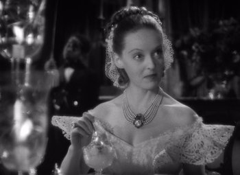 Movie still from “Jezebel” (1938), directed by William Wyler – A black and white photo of a woman in a white dress; Close Up shot, Over the shoulder angle