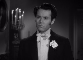 Movie still from “Jezebel” (1938), directed by William Wyler – A black and white photo of a man in a tuxedo; Close Up shot, Over the shoulder angle