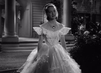 Movie still from “Jezebel” (1938), directed by William Wyler – A black and white photo of a woman in a wedding dress; Medium shot, Low angle