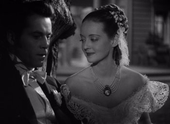 Movie still from “Jezebel” (1938), directed by William Wyler – A man and a woman in formal wear holding a parasol; Close Up shot, High angle