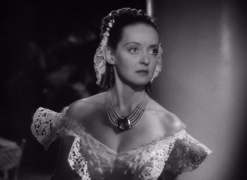 Movie still from “Jezebel” (1938), directed by William Wyler – A black and white photo of a woman in a dress; Close Up shot, Low angle