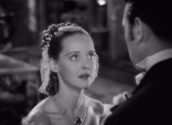 Movie still from “Jezebel” (1938), directed by William Wyler – A man and a woman are looking at each other in a black and white photo; Close Up shot, High angle