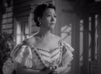 Movie still from “Jezebel” (1938), directed by William Wyler – An old photo of a woman in a dress; Close Up shot, High angle