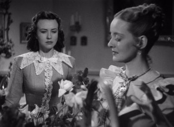 Movie still from “Jezebel” (1938), directed by William Wyler – Two young women are looking at each other in a room; Medium shot, Over the shoulder angle