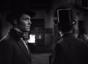 Movie still from “Jezebel” (1938), directed by William Wyler – A man in a top hat and a man in a suit; Medium shot, Over the shoulder angle