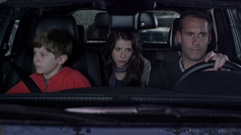 Movie still from “Turkey Hollow” (2015), directed by Kirk R. Thatcher – A woman and two men sitting in the back seat of a car; Medium shot, Over the shoulder angle