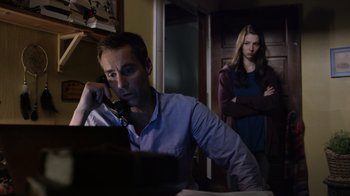 Movie still from “Turkey Hollow” (2015), directed by Kirk R. Thatcher – A man on the phone while a woman watches; Medium shot, Low angle