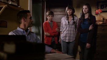 Movie still from “Turkey Hollow” (2015), directed by Kirk R. Thatcher – A group of people standing in a room; Medium shot, Over the shoulder angle