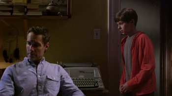 Movie still from “Turkey Hollow” (2015), directed by Kirk R. Thatcher – Two young men standing next to each other in front of an old typewriter; Medium shot, Over the shoulder angle