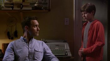 Movie still from “Turkey Hollow” (2015), directed by Kirk R. Thatcher – A man and a woman standing next to each other in front of a typewriter; Medium shot, Over the shoulder angle