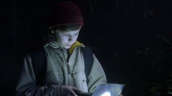 Movie still from “Turkey Hollow” (2015), directed by Kirk R. Thatcher – A young boy reading a book in the dark; Close Up shot, Low angle