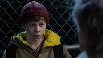 Movie still from “Turkey Hollow” (2015), directed by Kirk R. Thatcher – A young boy wearing a red hat and a yellow jacket; Close Up shot, Over the shoulder angle