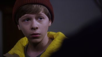 Movie still from “Turkey Hollow” (2015), directed by Kirk R. Thatcher – A young man wearing a red hat and a yellow jacket; Close Up shot, Over the shoulder angle