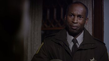 Movie still from “Turkey Hollow” (2015), directed by Kirk R. Thatcher – A man in a uniform is looking at the camera; Close Up shot, Over the shoulder angle