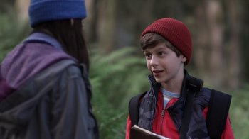 Movie still from “Turkey Hollow” (2015), directed by Kirk R. Thatcher – A young boy wearing a red hat talking to a woman in the woods; Close Up shot, Over the shoulder angle