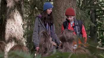 Movie still from “Turkey Hollow” (2015), directed by Kirk R. Thatcher – Two people are standing in the woods talking to each other; Medium shot, Over the shoulder angle