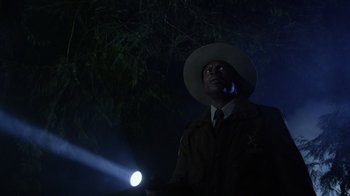 Movie still from “Turkey Hollow” (2015), directed by Kirk R. Thatcher – A man in a hat is holding a flashlight in the dark; Medium shot, Low angle