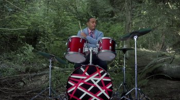 Movie still from “Turkey Hollow” (2015), directed by Kirk R. Thatcher – A man playing drums in the woods with trees in the background; Medium shot, Over the shoulder angle