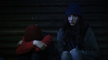 Movie still from “Turkey Hollow” (2015), directed by Kirk R. Thatcher – A woman sitting next to another woman on a bench; Medium shot, Low angle