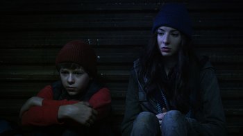 Movie still from “Turkey Hollow” (2015), directed by Kirk R. Thatcher – A boy and a girl sitting next to each other; Close Up shot, Low angle