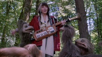 Movie still from “Turkey Hollow” (2015), directed by Kirk R. Thatcher – A woman holding an instrument in front of three other people; Medium shot, Low angle
