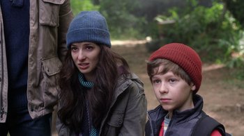 Movie still from “Turkey Hollow” (2015), directed by Kirk R. Thatcher – Two young people wearing winter hats in a wooded area; Close Up shot, Over the shoulder angle
