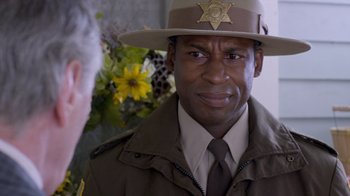 Movie still from “Turkey Hollow” (2015), directed by Kirk R. Thatcher – A man in a sheriff's uniform and a hat; Close Up shot, Over the shoulder angle
