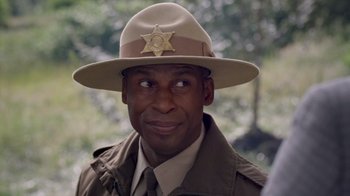 Movie still from “Turkey Hollow” (2015), directed by Kirk R. Thatcher – A man in a uniform and a sheriff's hat; Close Up shot, Over the shoulder angle