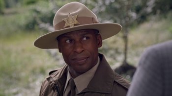 Movie still from “Turkey Hollow” (2015), directed by Kirk R. Thatcher – A man in a uniform and a sheriff's hat; Close Up shot, Over the shoulder angle