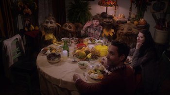 Movie still from “Turkey Hollow” (2015), directed by Kirk R. Thatcher – A group of people sitting at a table with a plate of food; Medium shot, High angle
